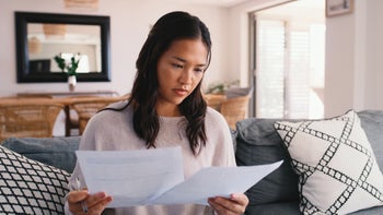 FSA HSA: woman reviewing paperwork at home 2181519924