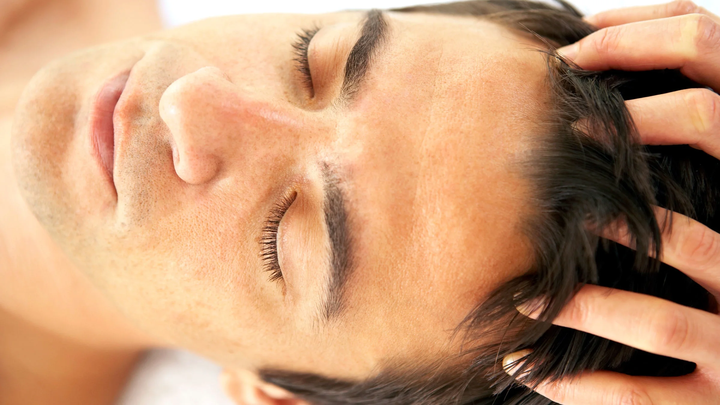 Cyclist lying on the road and holding his head
