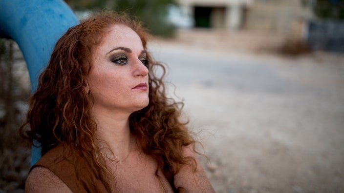 A portrait of a pensive person outside.