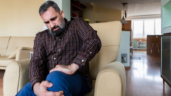 Health: Statins: older man holding his knee in pain-1203835230