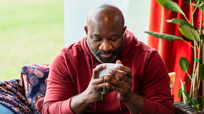 A man drinks a cup of tea.