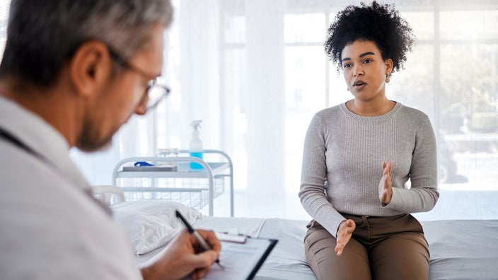A woman talks with a healthcare professional. 