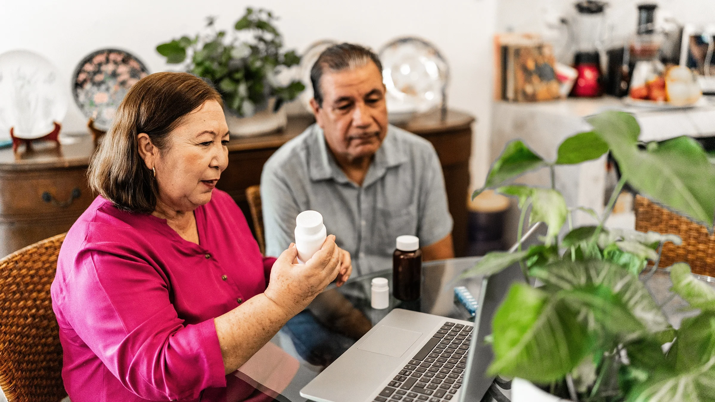 An older couple is talking to a healthcare professional on a video call at home.