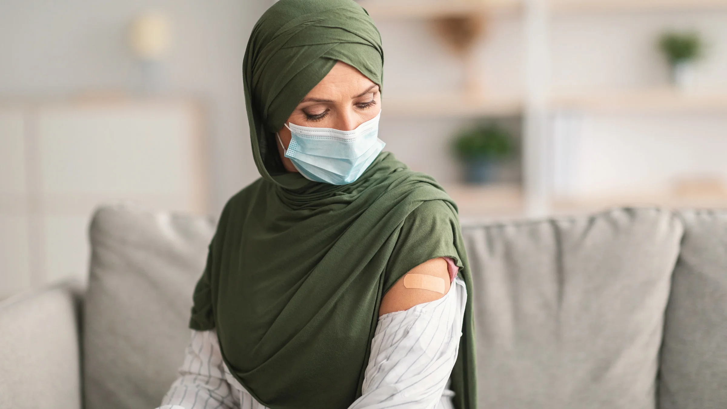 A person with a vaccine bandaid on their arm.