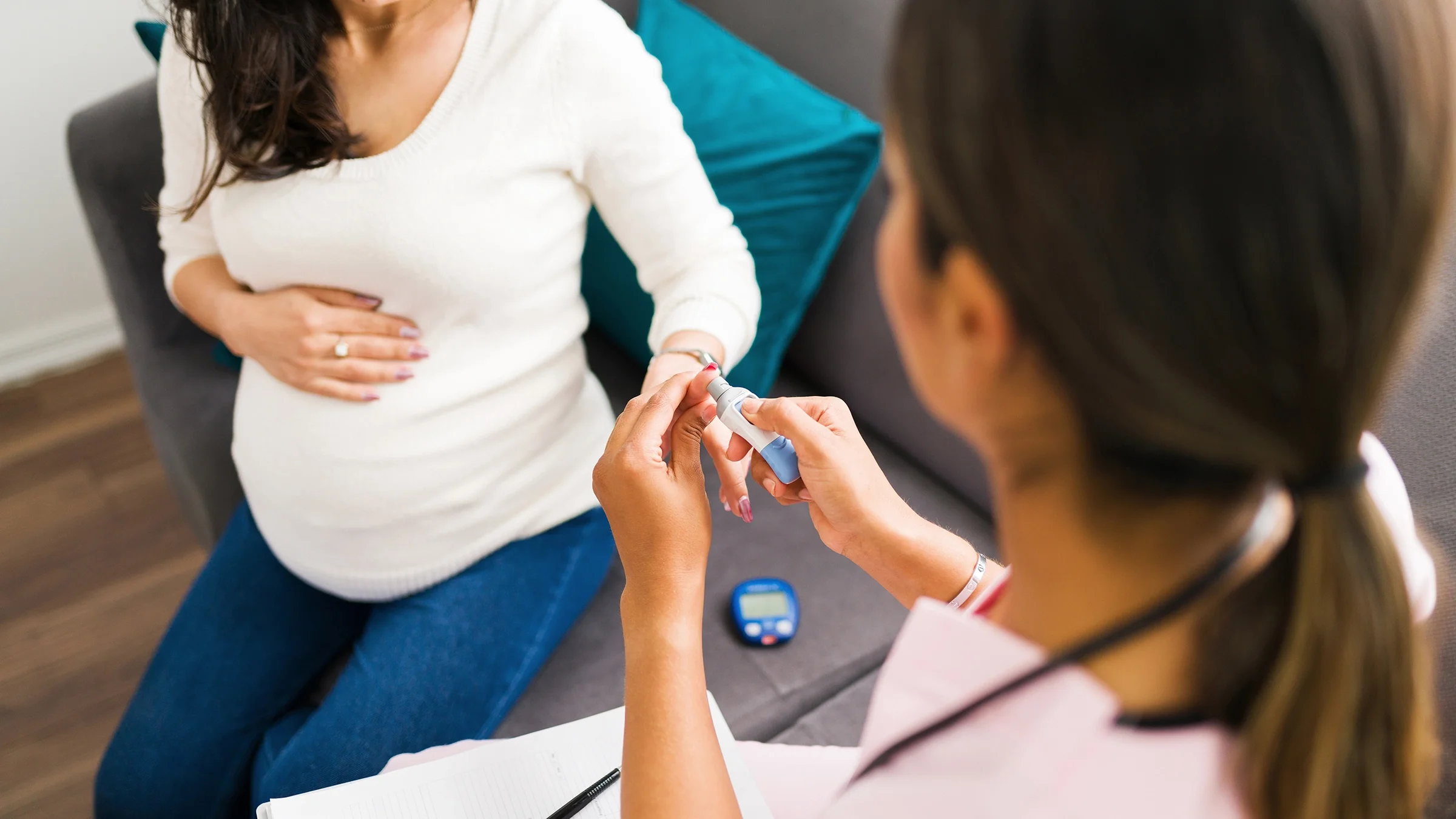 A nurse is measuring blood sugar levels of a pregnant woman.
