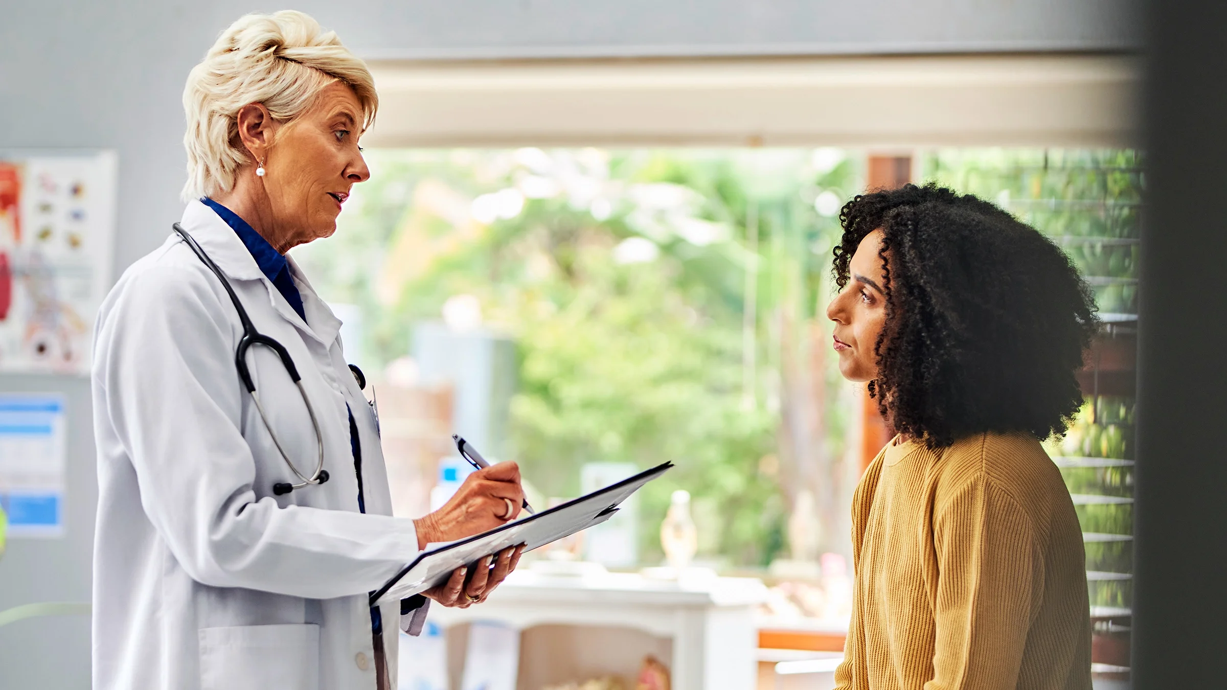 A doctor writes a prescription for a patient.