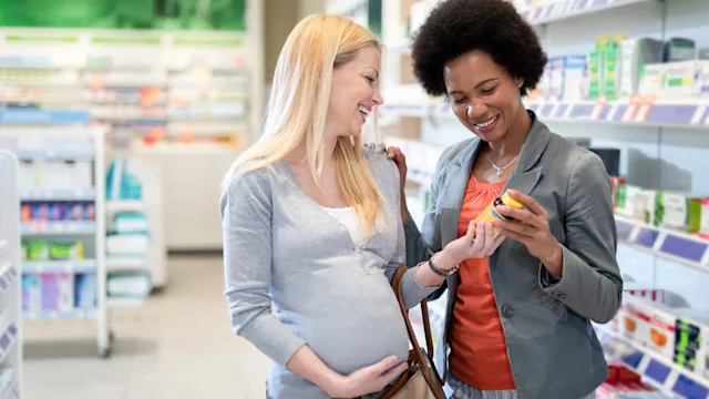 Health: Pregnancy: pregnant woman with friend at pharmacy-1246600922
