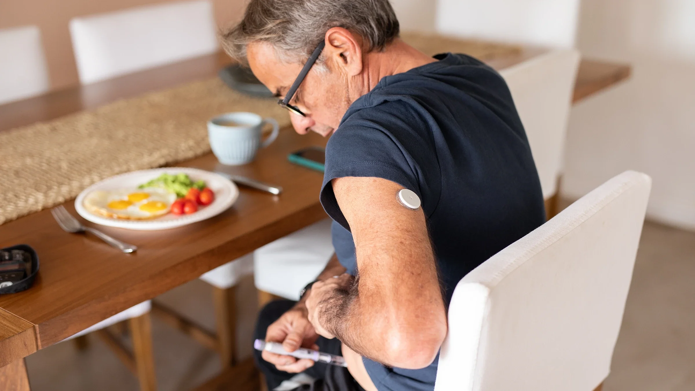 A man injects himself with insulin before breakfast.