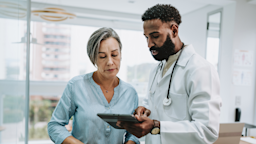 A healthcare professional talks to a patient while holding a digital tablet.
andreswd/E+ via Getty Images 