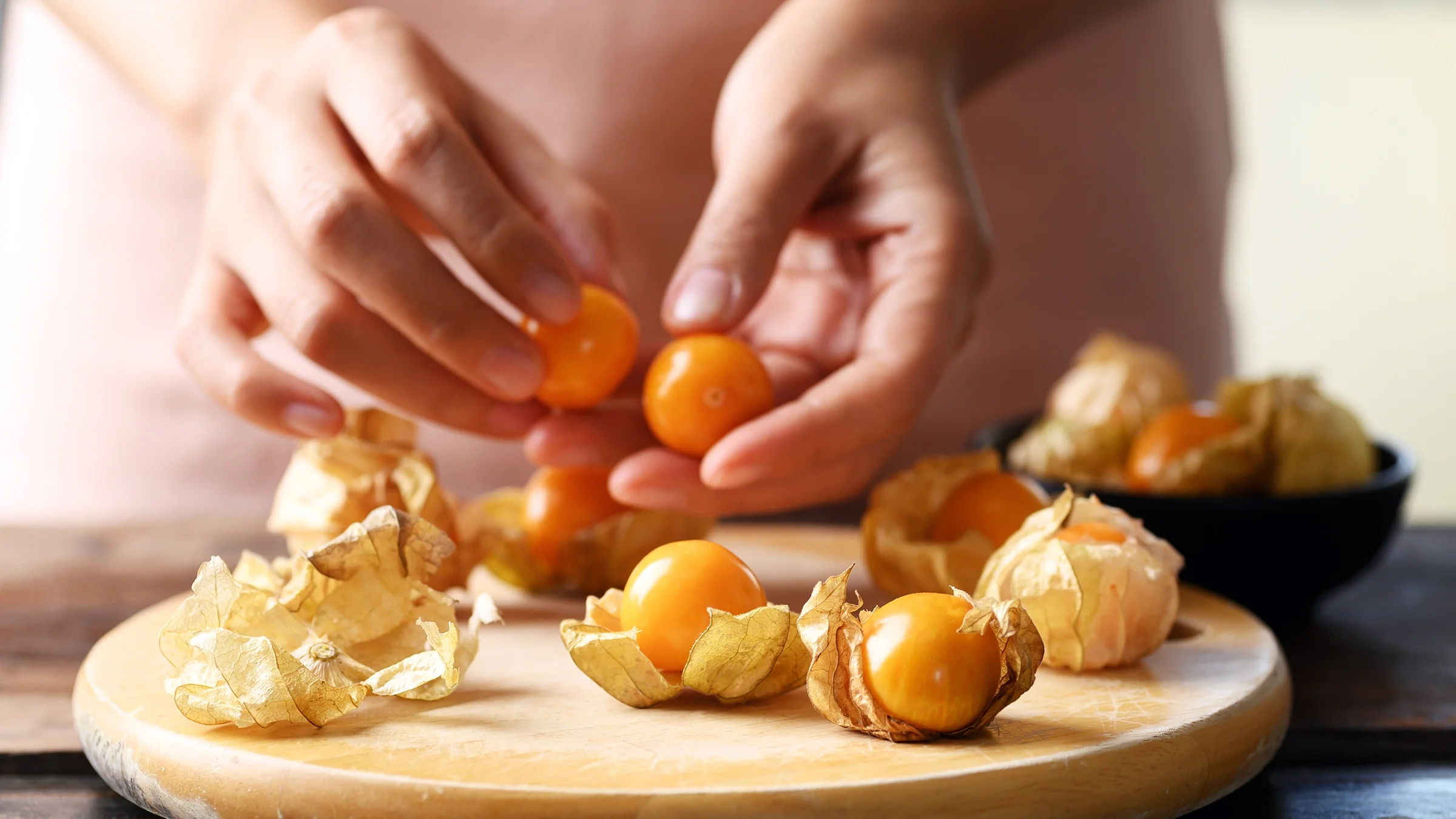 Close-up of a woman's hands peeling golden berries
