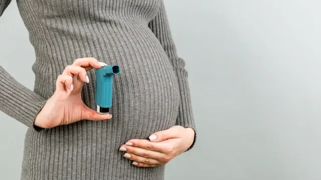 Health: Asthma: pregnant woman holding inhaler next to belly-1294463657