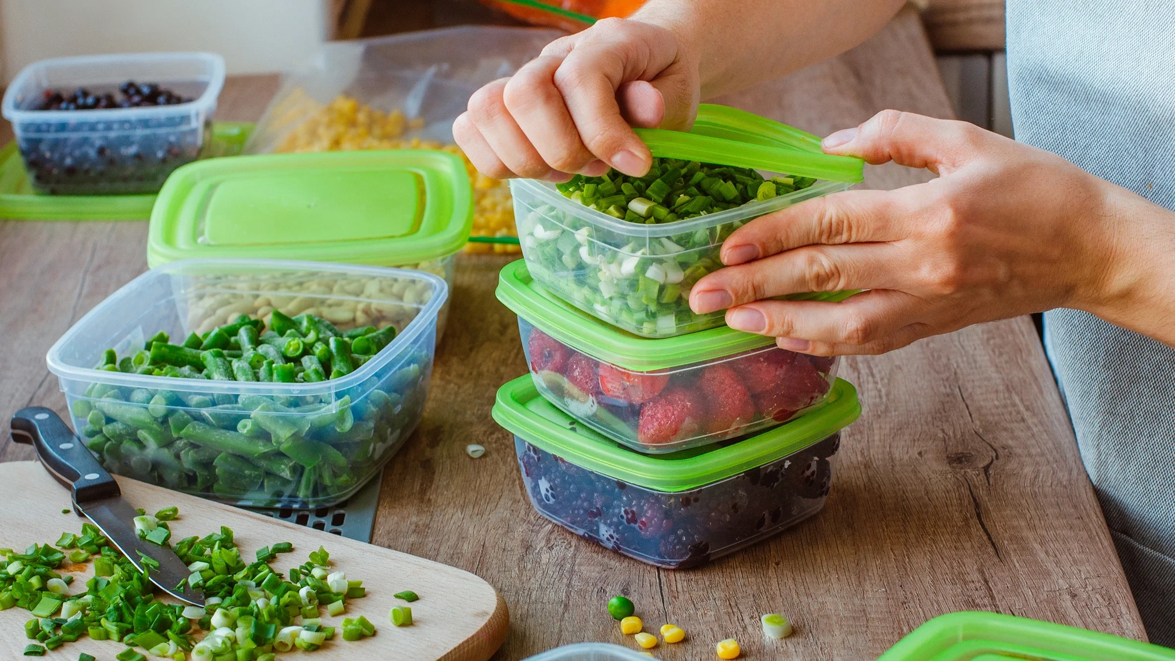 A close-up image shows an adult preparing fruit and vegetables in containers.