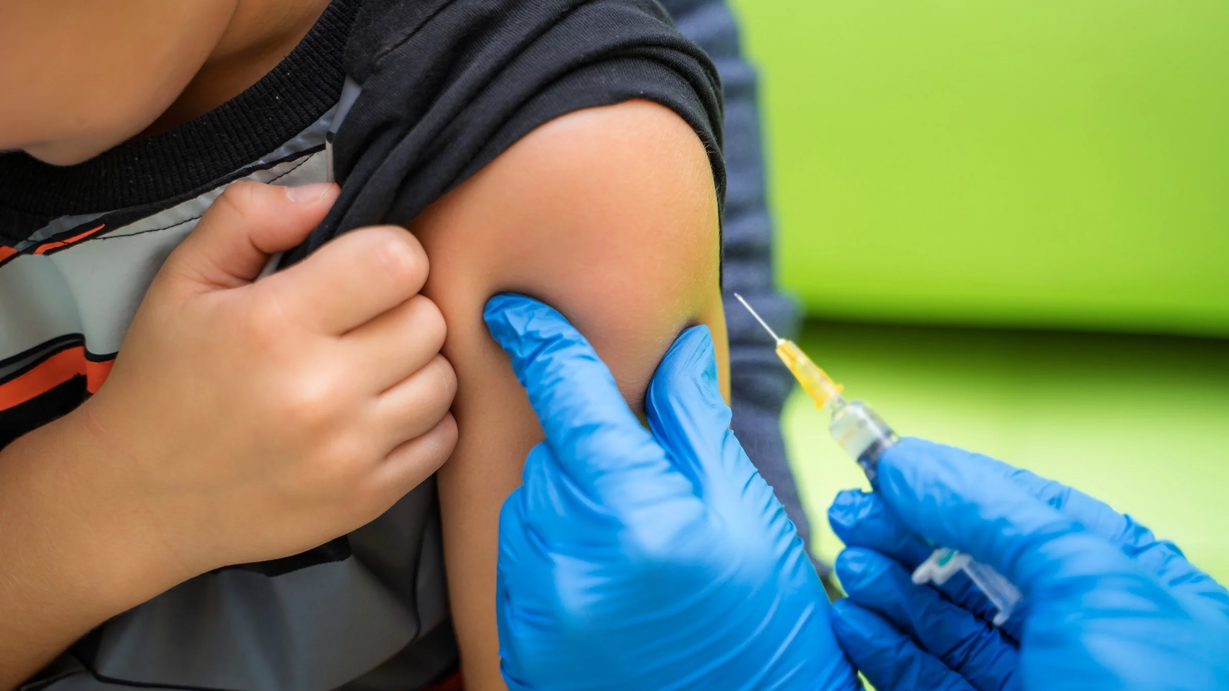 Cropped shot of a young boy rolling up his t-shirt sleeve as he is getting a shot.