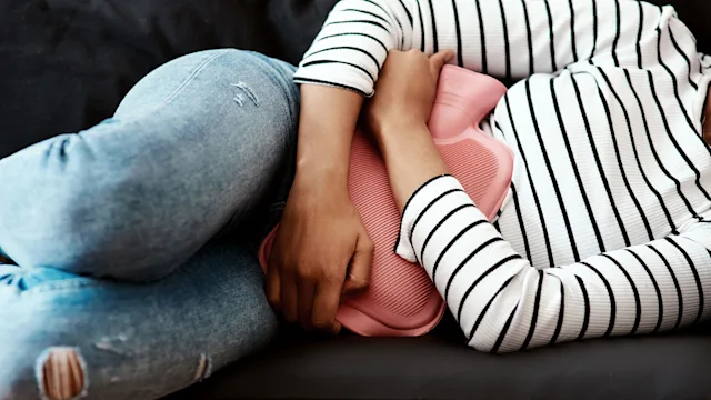 Health: Menstrual pain: closeup woman with hot water bottle 1286693128