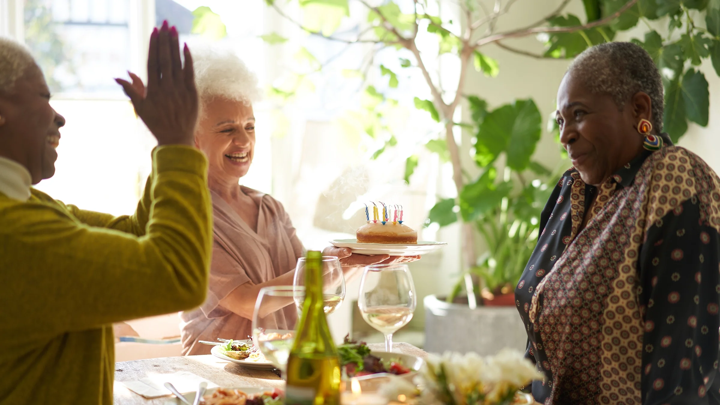 Three senior women celebrate a birthday.