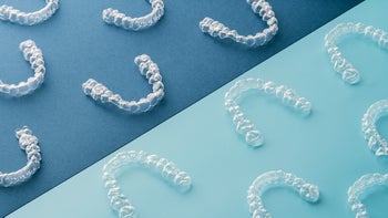 Dental Care: clear dental aligners on blue background 1256716140