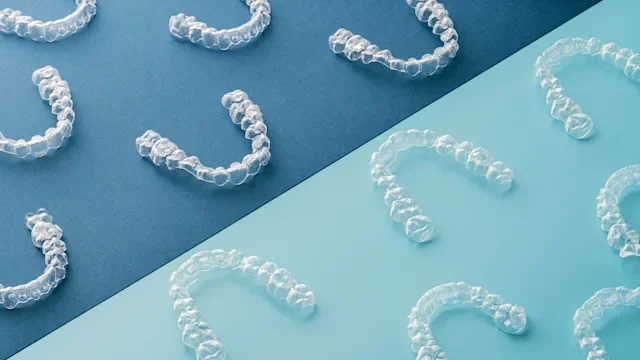 Dental Care: clear dental aligners on blue background 1256716140