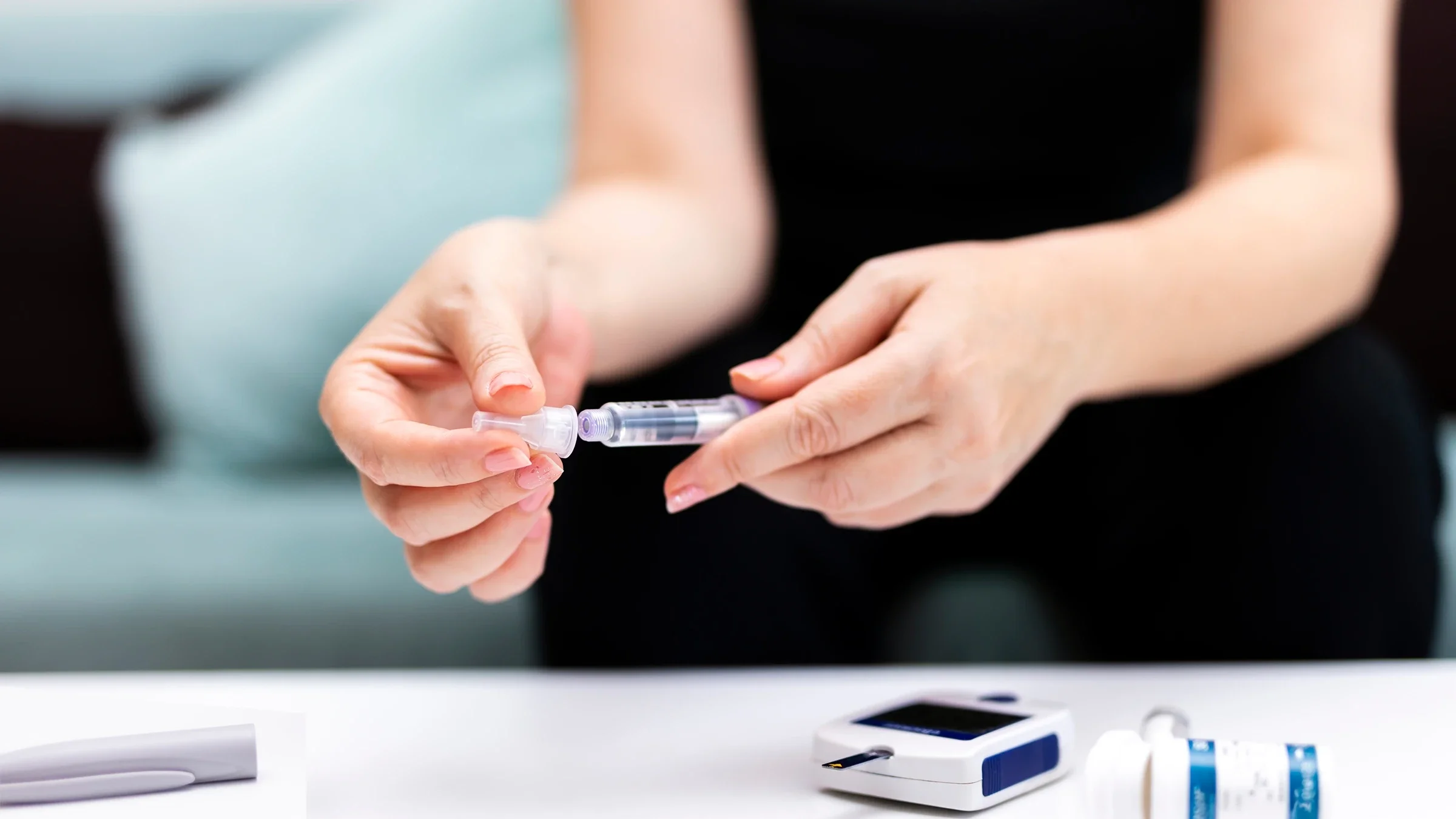 Close-up of a woman opening an insulin pen.