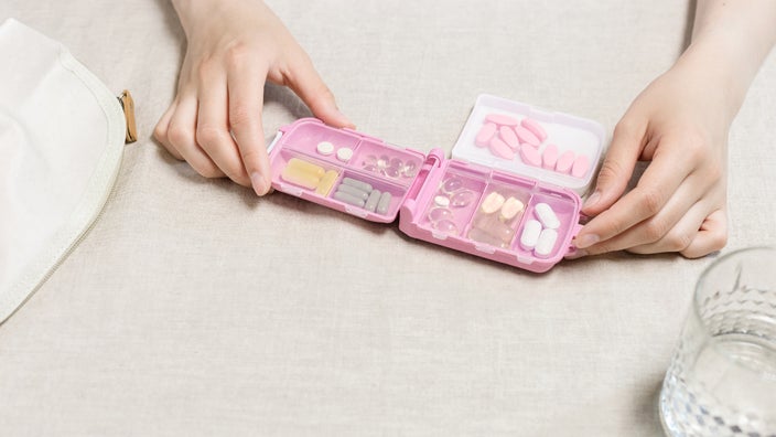A person opening their pill container.