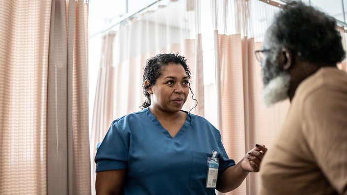 A doctor speaks with a patient during a medical appointment in a hospital.