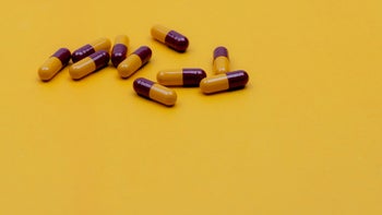 Health: Penicillin antibiotics: yellow red pills yellow background-1342608990