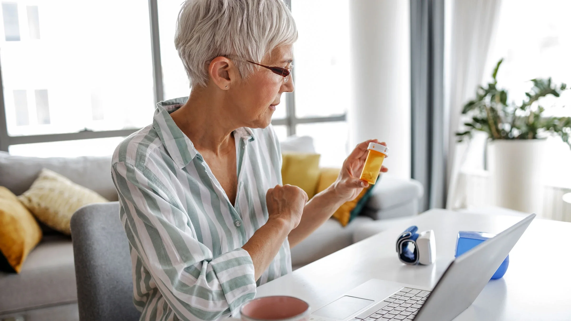 Senior woman reading instructions on Rx bottle.