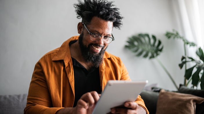 A man uses a digital tablet at home.