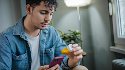 Pictured is a man reading an Rx bottle.
Milko/E+ via Getty Images