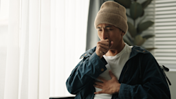 A man is coughing and holding his chest in pain.
pocketlight/iStock via Getty Images Plus