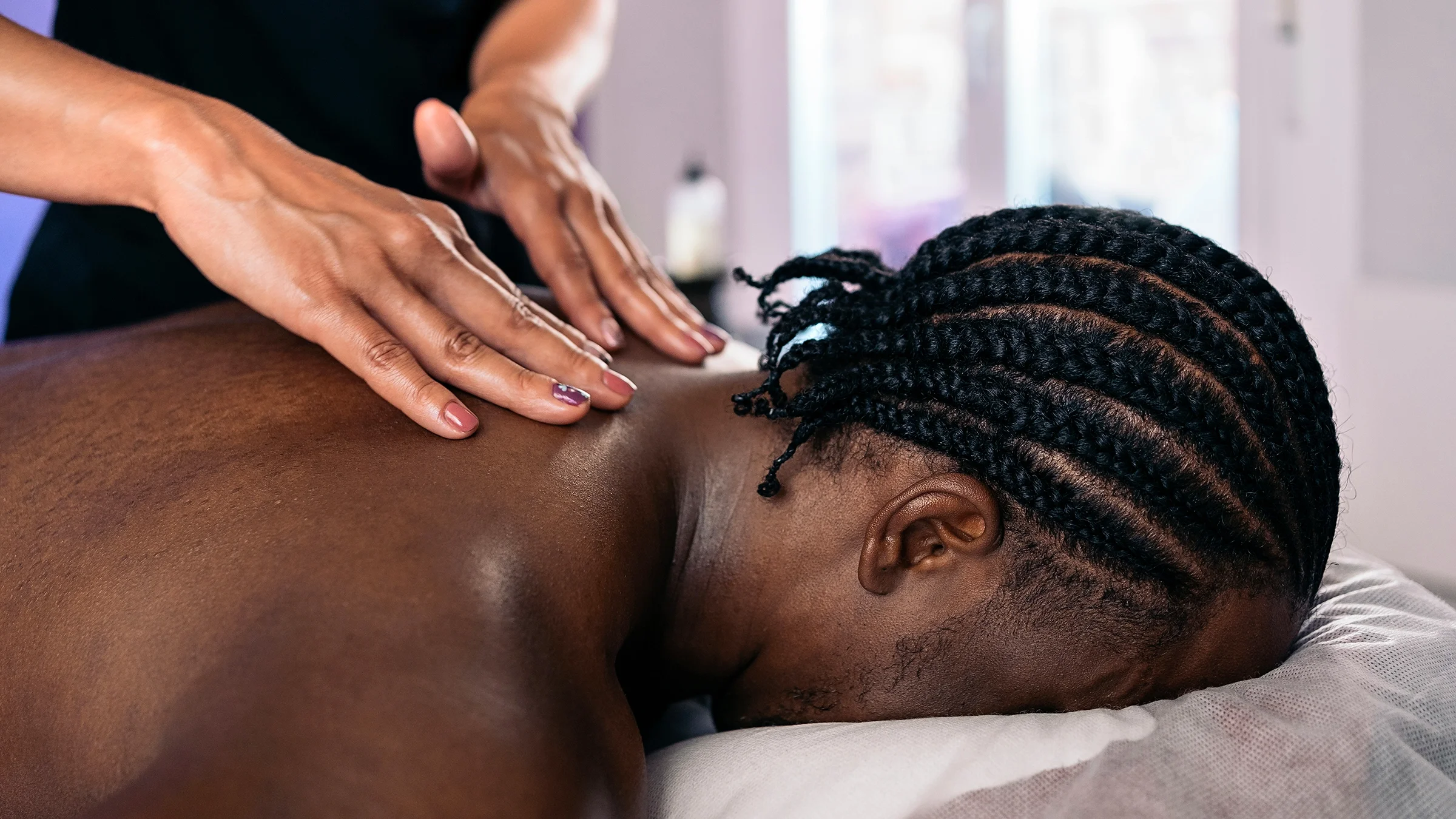Close-up man lying down and receiving a massage.