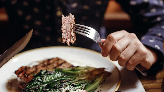 Diet nutrition: closeup person eating steak 1060835204