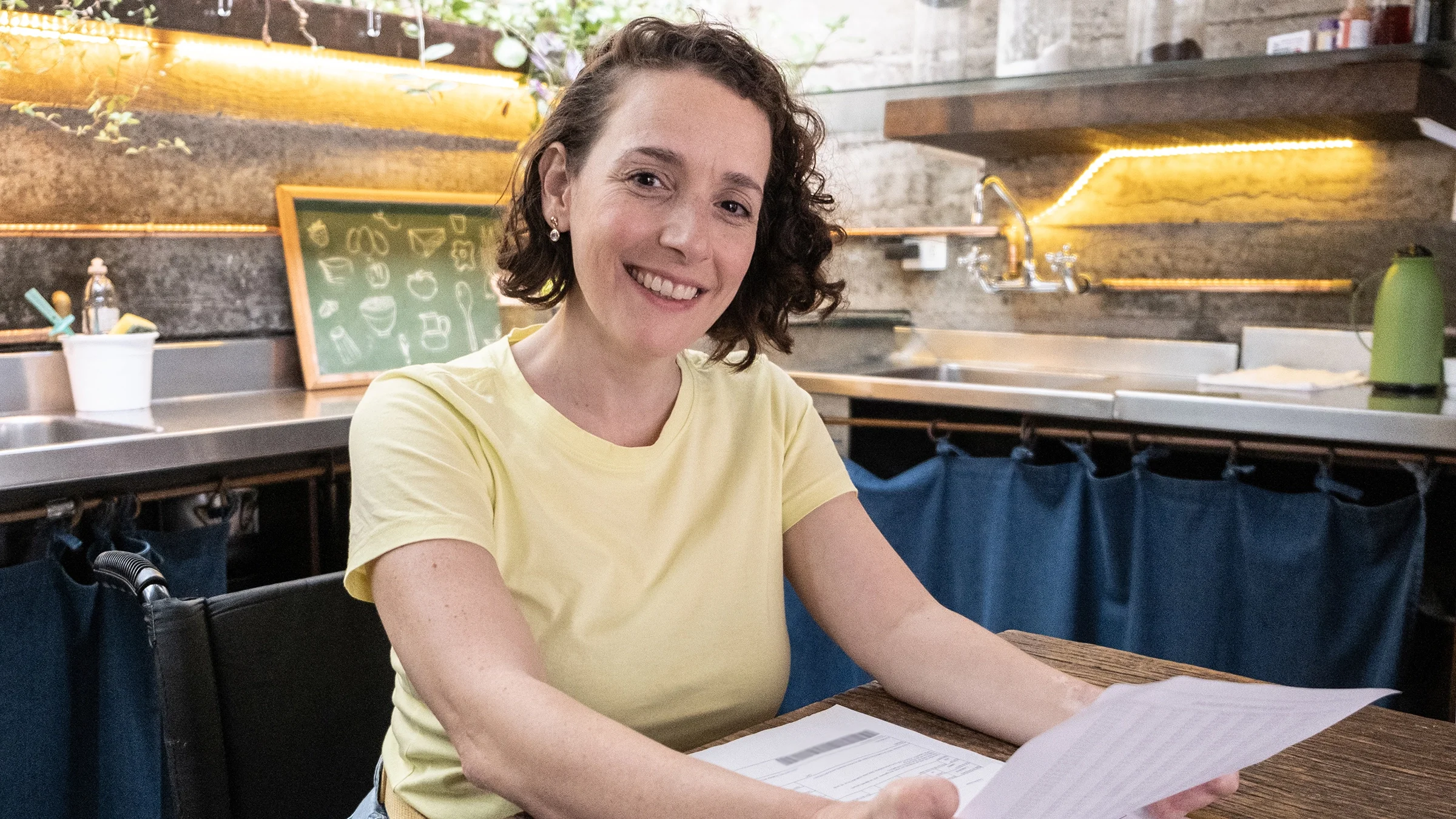 Portrait of a young woman in her home, reviewing paperwork.