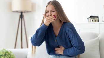 Nausea: woman covering mouth feeling nausea 2175396754