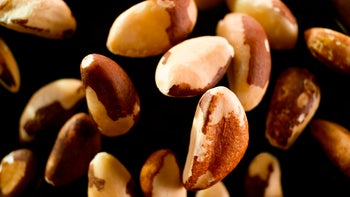 diet-nutrition: brazil nuts falling onto black surface 1328856191