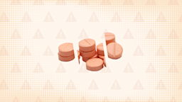 In the center of an orange background with texture and warning sign pattern is a pile of chalky orange pills cut into thirds. 
GoodRx Health