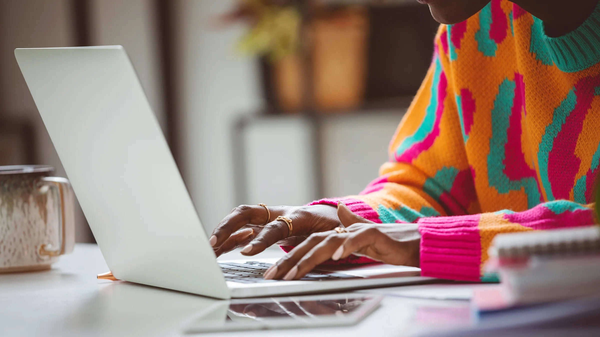Close-up of a woman typing on laptop keyboard