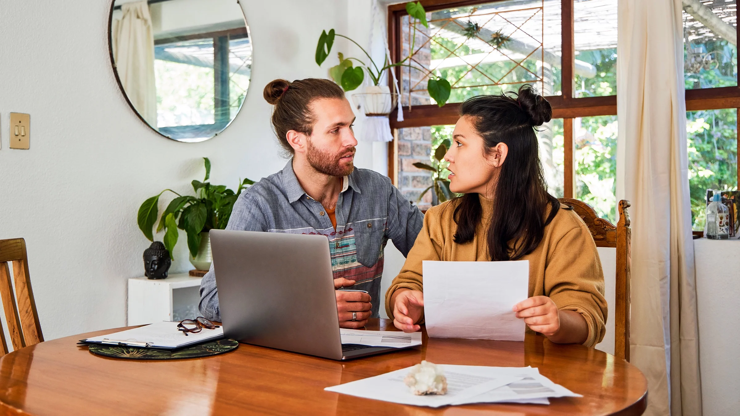 A couple is discussing paperwork at home.