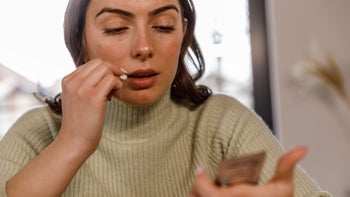 Opioids: woman reading pill pack 1479707998