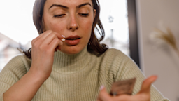 Woman reading a label on a pill packet
fotostorm/E+ via Getty Images