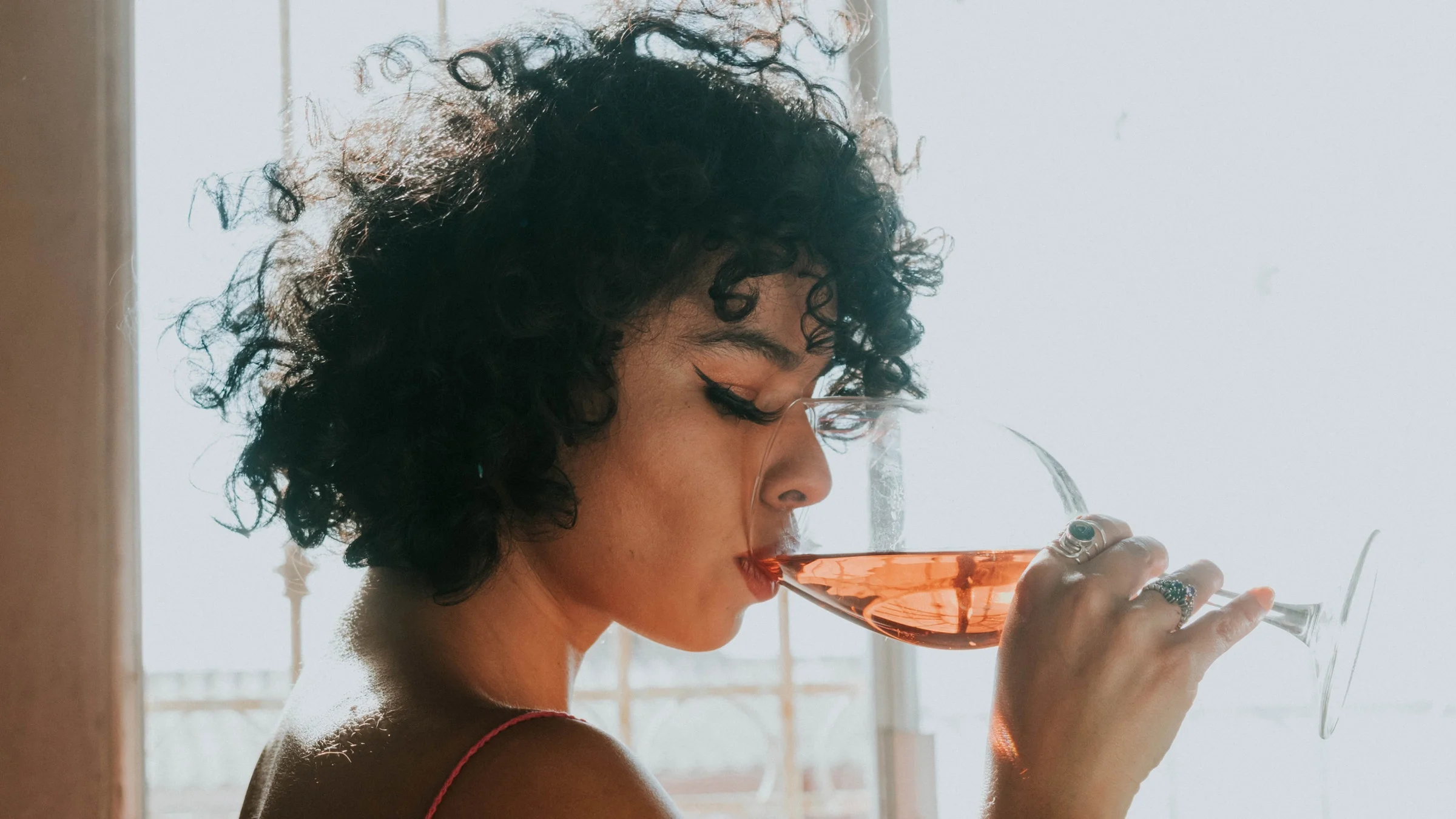 Side profile of someone drinking wine.