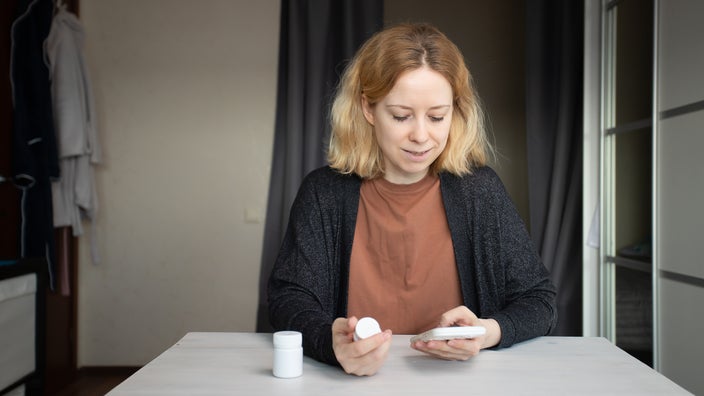 A woman orders medicine using her phone.