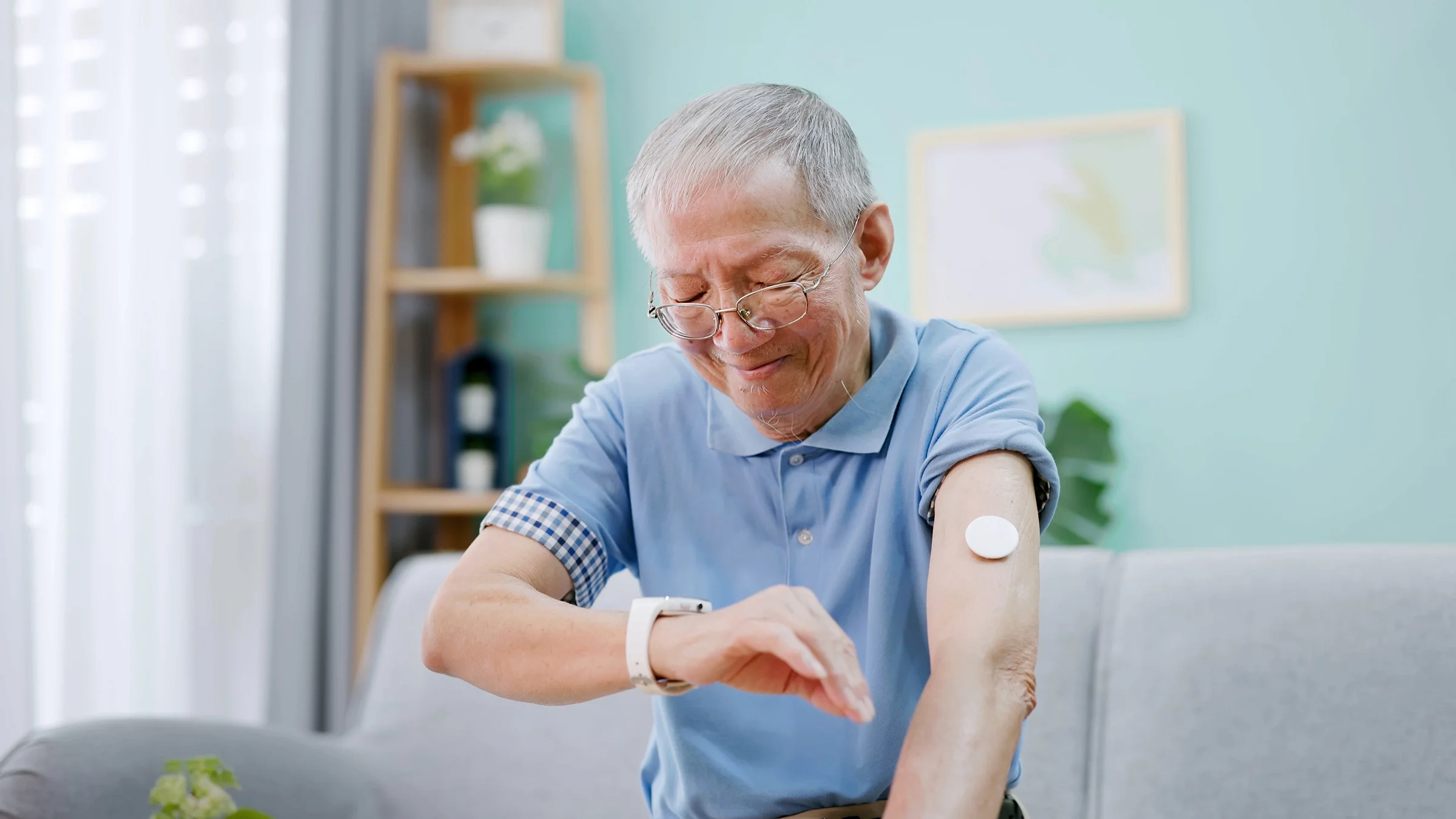 Older man using CGM with smartwatch.