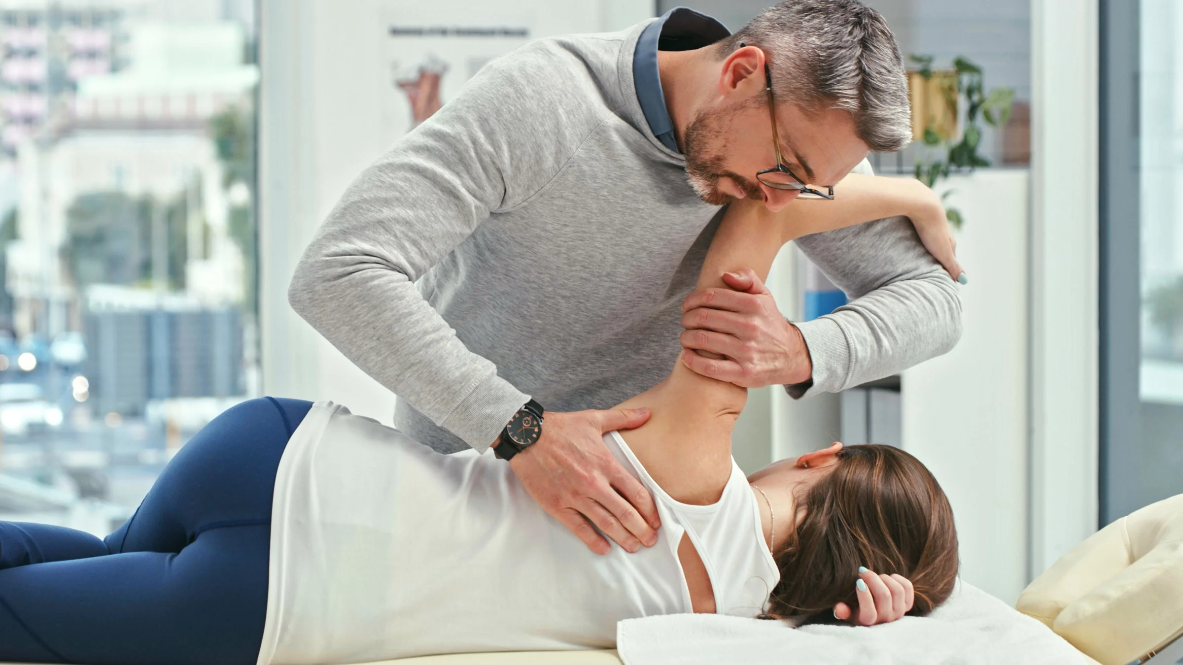 A chiropractor adjusting a patient's body.