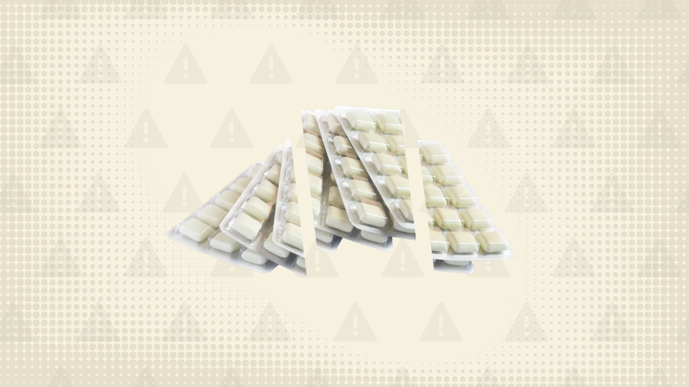 Yellowish white background with texture and warning sign pattern. In the center are blister packs of nicotine gum cut into thirds. 
GoodRx Health