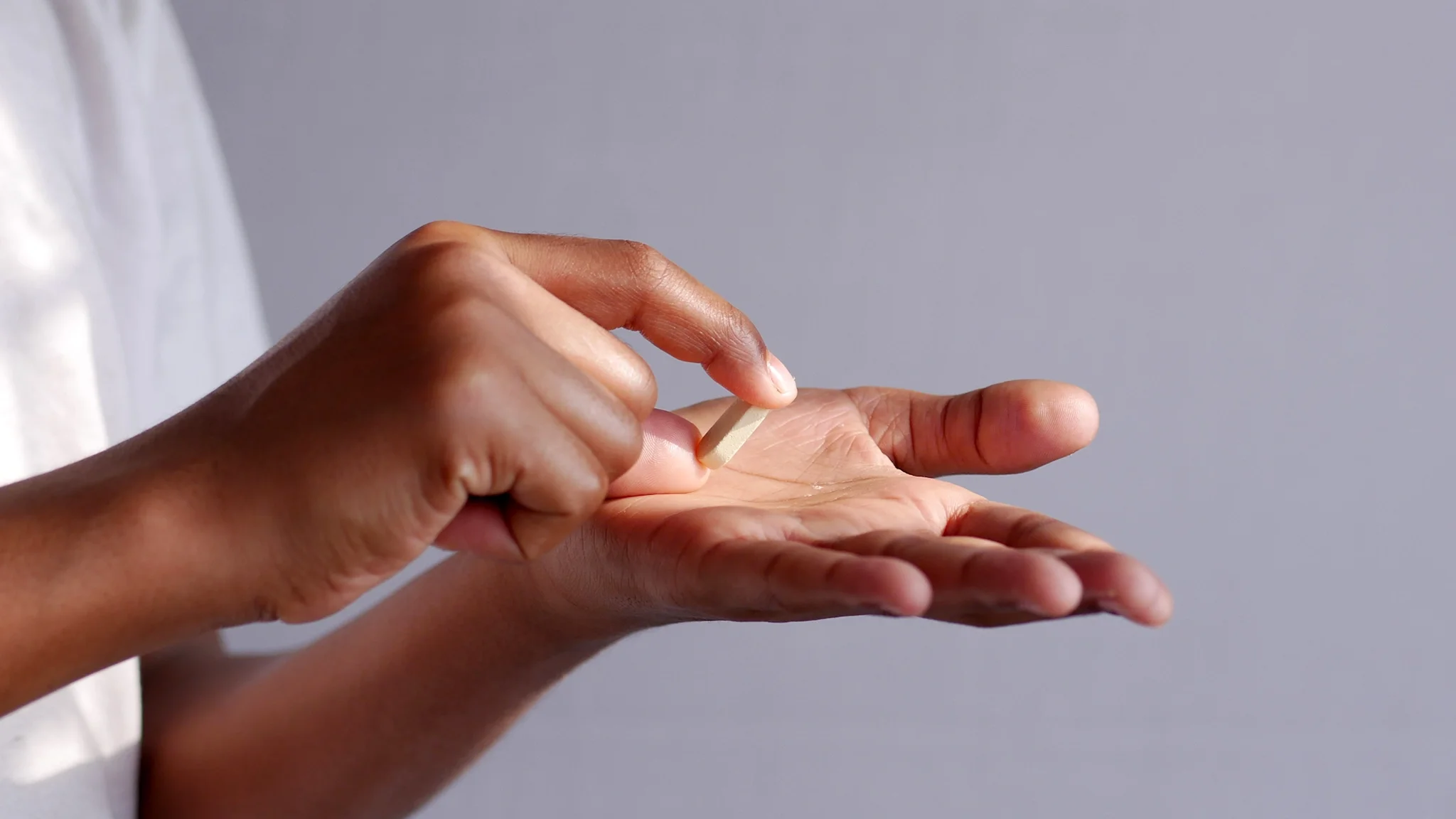 Close-up of hand holding a pill