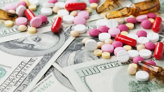 colorful pills on hundred dollar bills-490802884