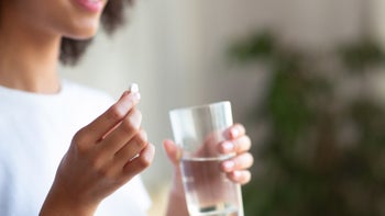 Januvia: cropped holding pill glass of water 1302978996