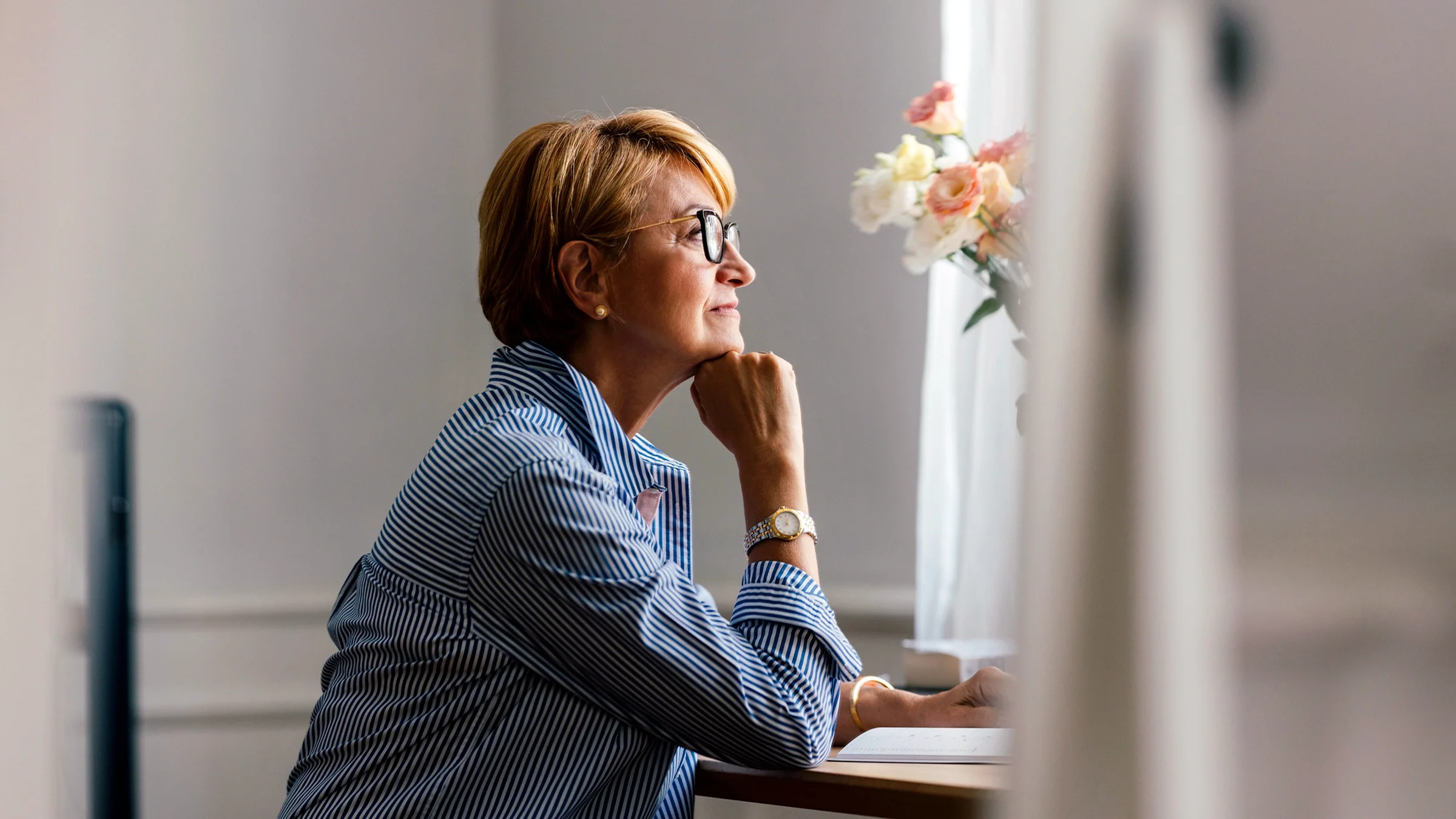 A woman looks pensive while journaling.