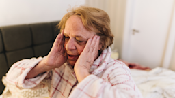 A woman presses her fingers to her temples in a moment of worry.
FG Trade/E+ via Getty Images
