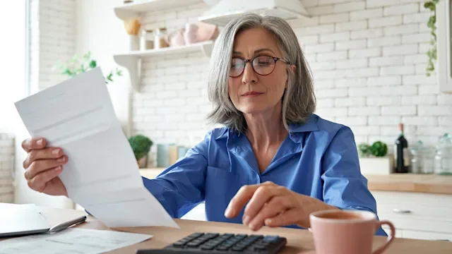 Health: Medicare: senior woman reviewing paperwork-1281173455